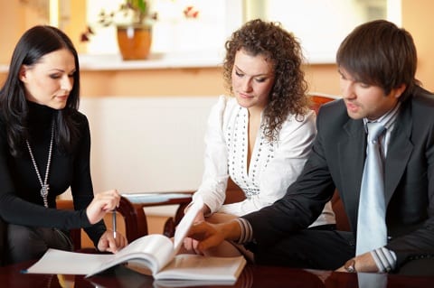 Couple reviewing paperwork with Realtor